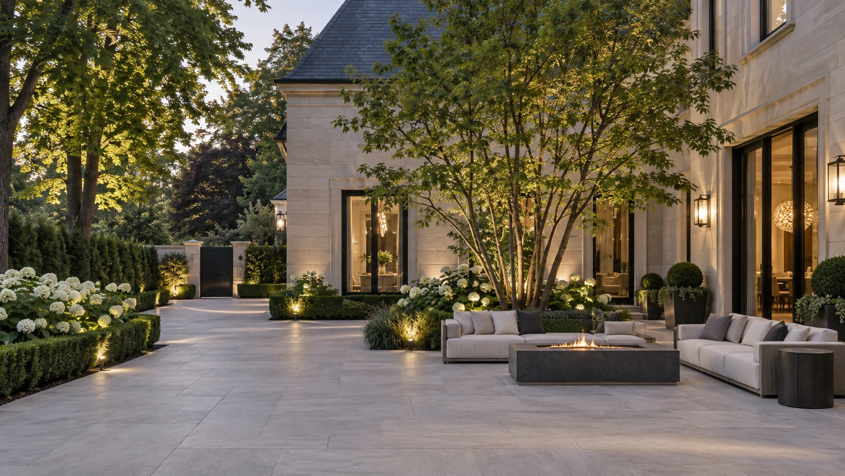 Private stone courtyard with a sculptural tree and an outdoor lounge